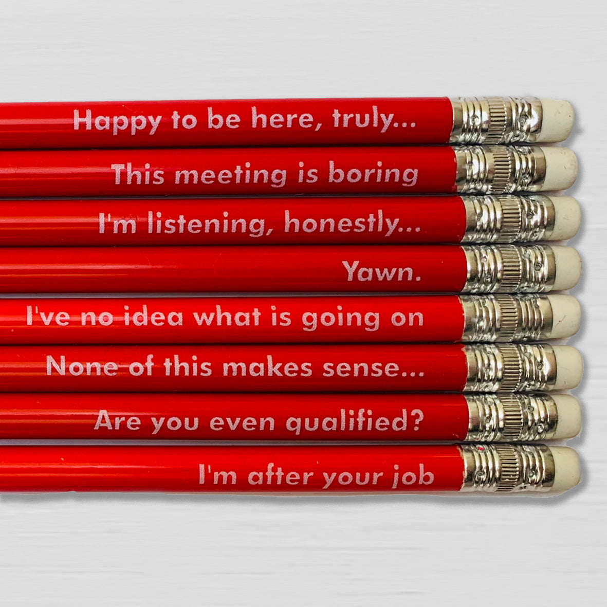 Number Ninety Five; 8 red pencils with a silver ferrule and white eraser, with Passive Aggressive sayings, such as 'this meeting is boring, or I have no idea what is going on' written in a white text. 