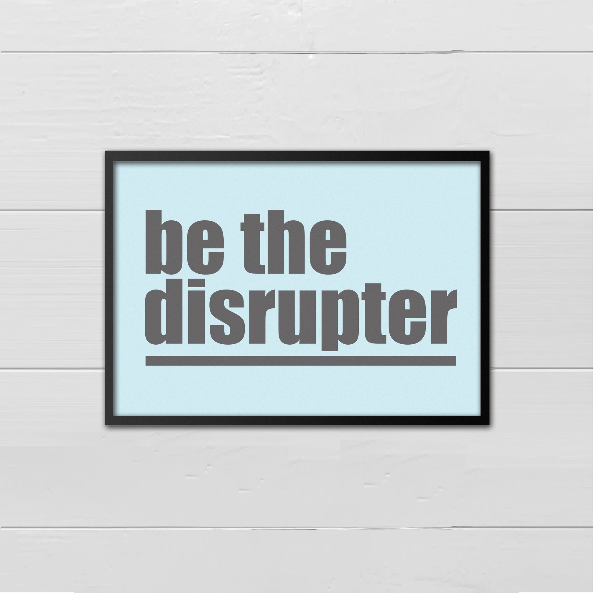 Landscape style print with the words Be The Disrupter underlined and written in grey onto a pale blue back ground