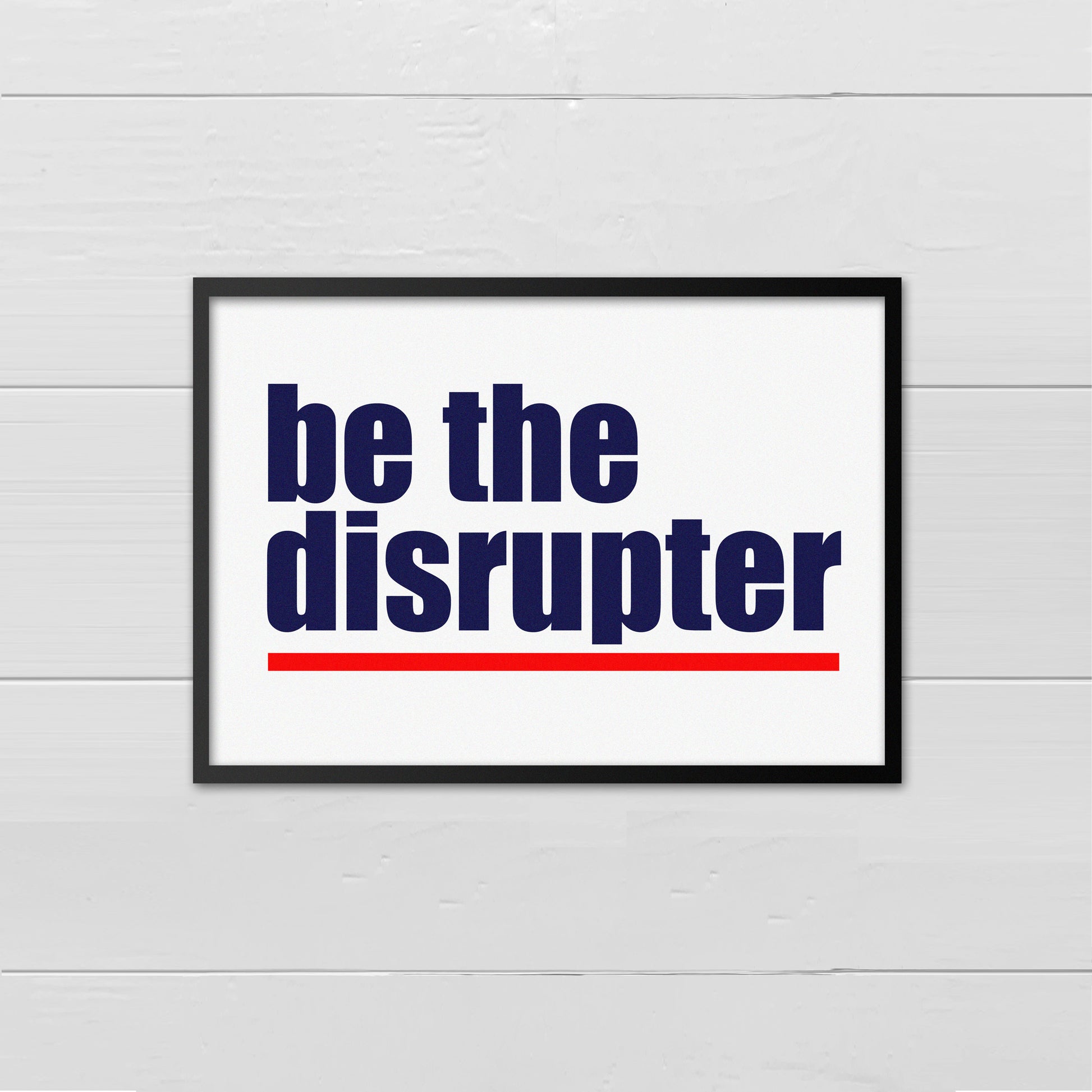 Landscape style print with the words Be The Disrupter written in navy blue and underlined in red onto a white back ground