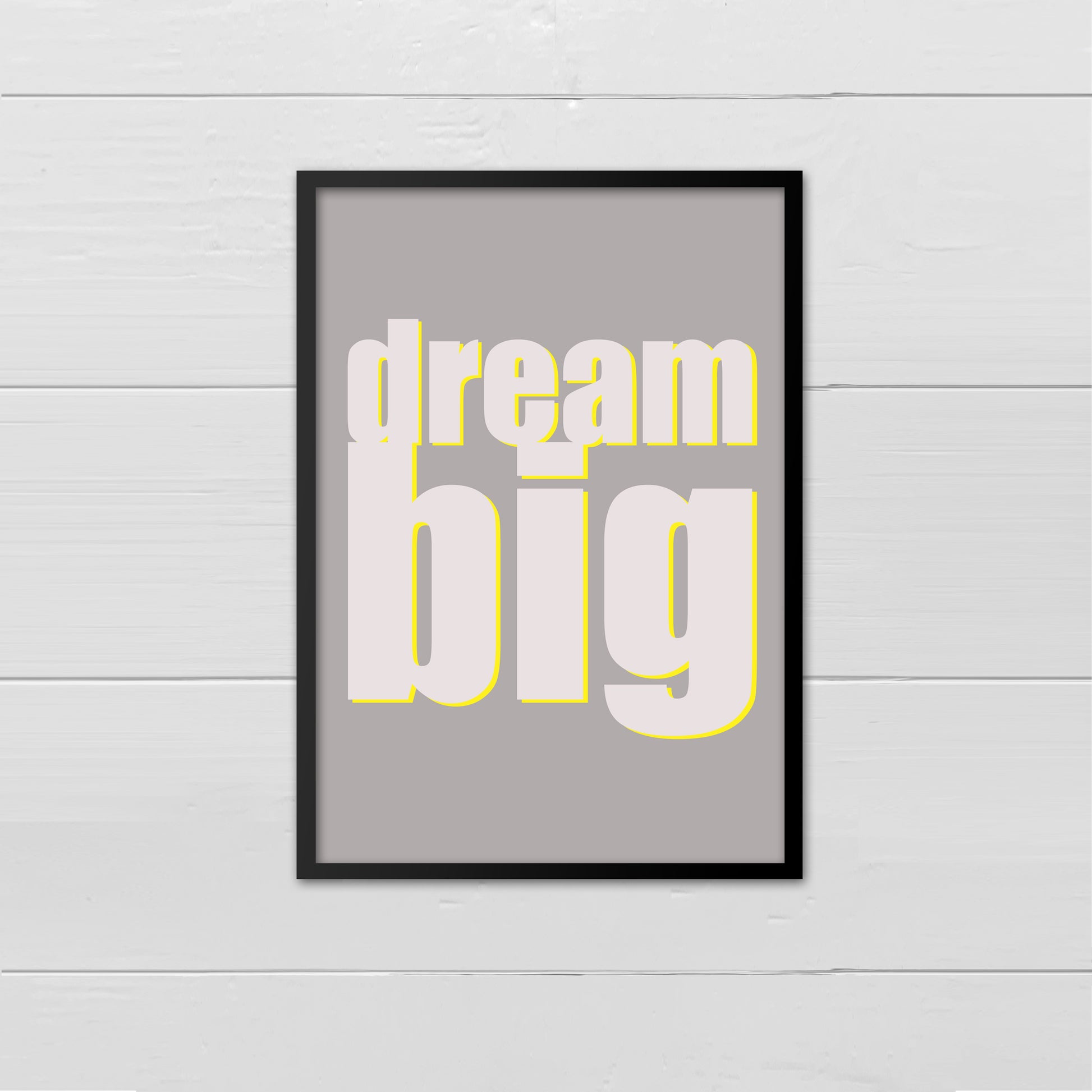 Portrait style print with the words Dream Big printed in large lowercase letters in pale grey, with a bright yellow drop shadow onto a mid grey cream background